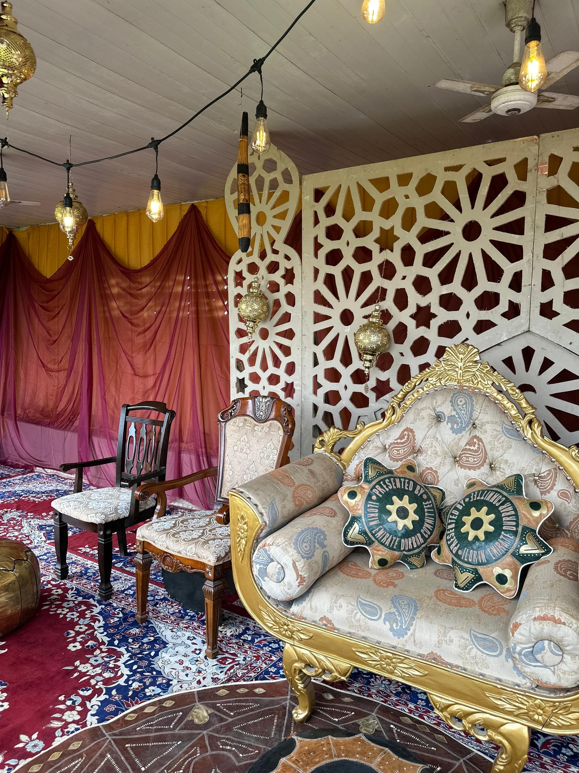 Durbar ceremony Lagos, ceremonial stage with rich jewel-tone fabric and lantern clusters